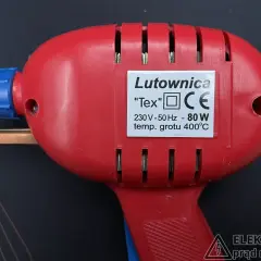 Czerwona lutownica "Tex" z niebieskim elementem, o mocy 80W i temperaturze grotu 400°C. Posiada oznaczenie CE, wskazujące na zgodność z normami bezpieczeństwa, w tym klasy ochronności.