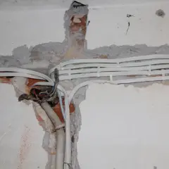 Nowe kable elektryczne w ścianie, przygotowanie do wymiany instalacji elektrycznej. Widoczne przewody i puszka instalacyjna.