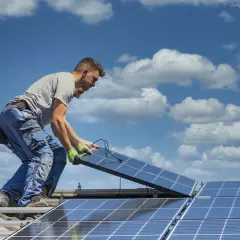Instalator montuje panele fotowoltaiczne na dachu. Dbałość o szczegóły i ekologiczne rozwiązania dla każdego prosumenta.