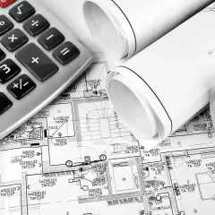 Kalkulator i zwinięte plany instalacji elektrycznej domu.