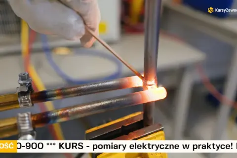 Ręka w rękawiczce wykonuje lutowanie miedzi. Dwa rozgrzane do czerwoności miedziane przewody są łączone za pomocą cienkiego drutu.