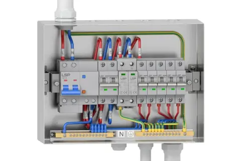 Wnętrze metalowej skrzynki elektrycznej z widocznym głównym wyłącznikiem 32A i kilkoma mniejszymi wyłącznikami 16A, wszystko starannie okablowane.