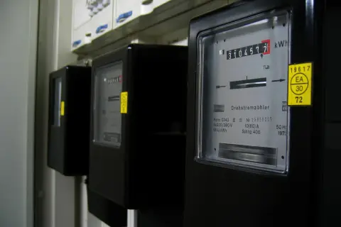 Trzy liczniki energii elektrycznej, każdy z wyświetlaczem pokazującym zużycie w kWh. To jednostka pracy i energii.
