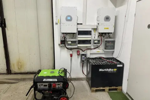 System magazynowania energii do fotowoltaiki: dwa falowniki, skrzynka z bezpiecznikami, agregat prądotwórczy i duży magazyn akumulatorów NorthBaH.