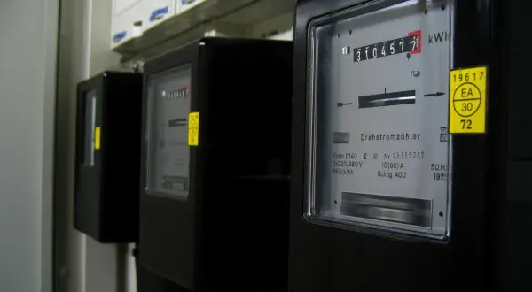 Trzy liczniki energii elektrycznej, każdy z wyświetlaczem pokazującym zużycie w kWh. To jednostka pracy i energii.