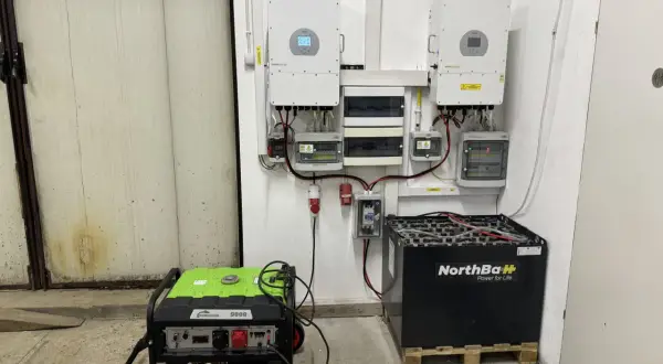 System magazynowania energii do fotowoltaiki: dwa falowniki, skrzynka z bezpiecznikami, agregat prądotwórczy i duży magazyn akumulatorów NorthBaH.