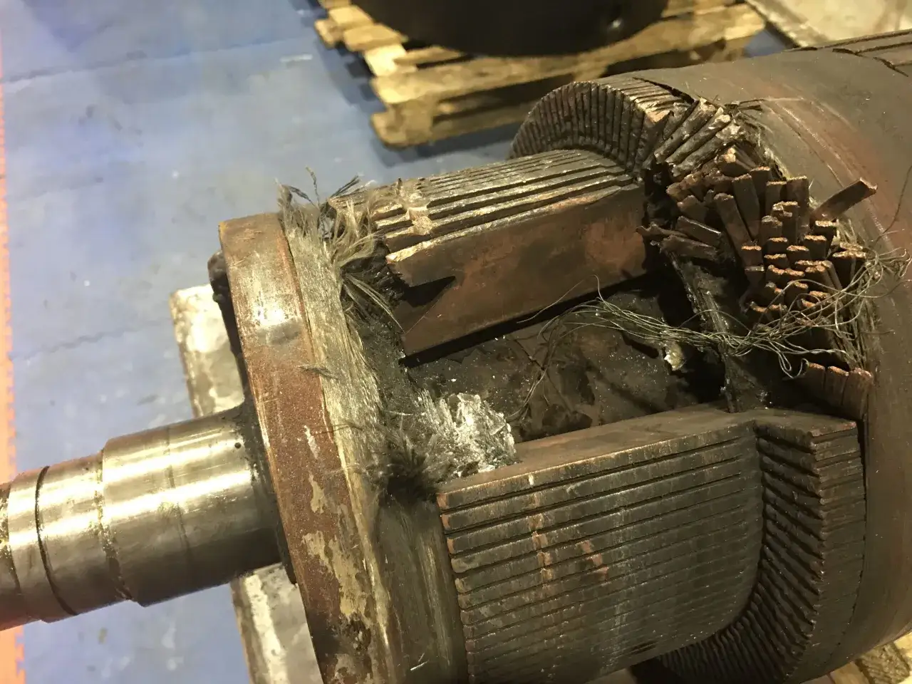 Uszkodzony komutator silnika elektrycznego z widocznymi spalenizną i zerwanymi uzwojeniami.
