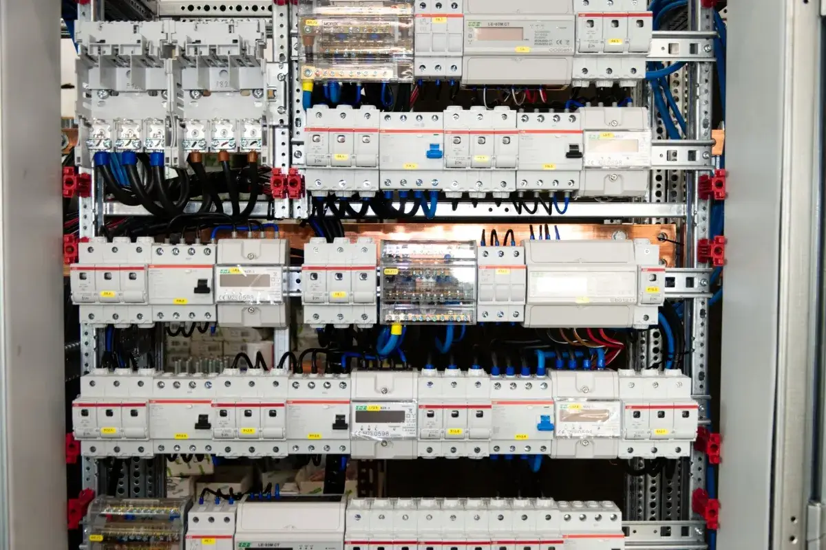 Panel elektryczny z licznymi wyłącznikami i przewodami. Taki widok często towarzyszy ocenie koszt instalacji elektrycznej.