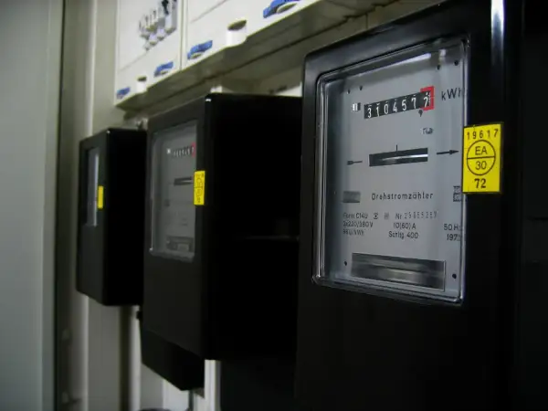 Trzy liczniki energii elektrycznej, każdy z wyświetlaczem pokazującym zużycie w kWh. To jednostka pracy i energii.
