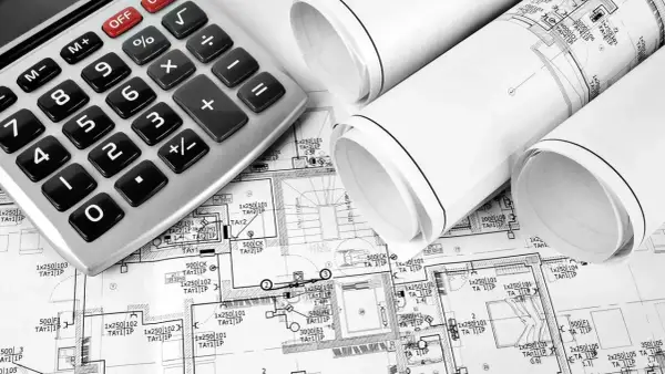 Kalkulator i zwinięte plany instalacji elektrycznej domu.